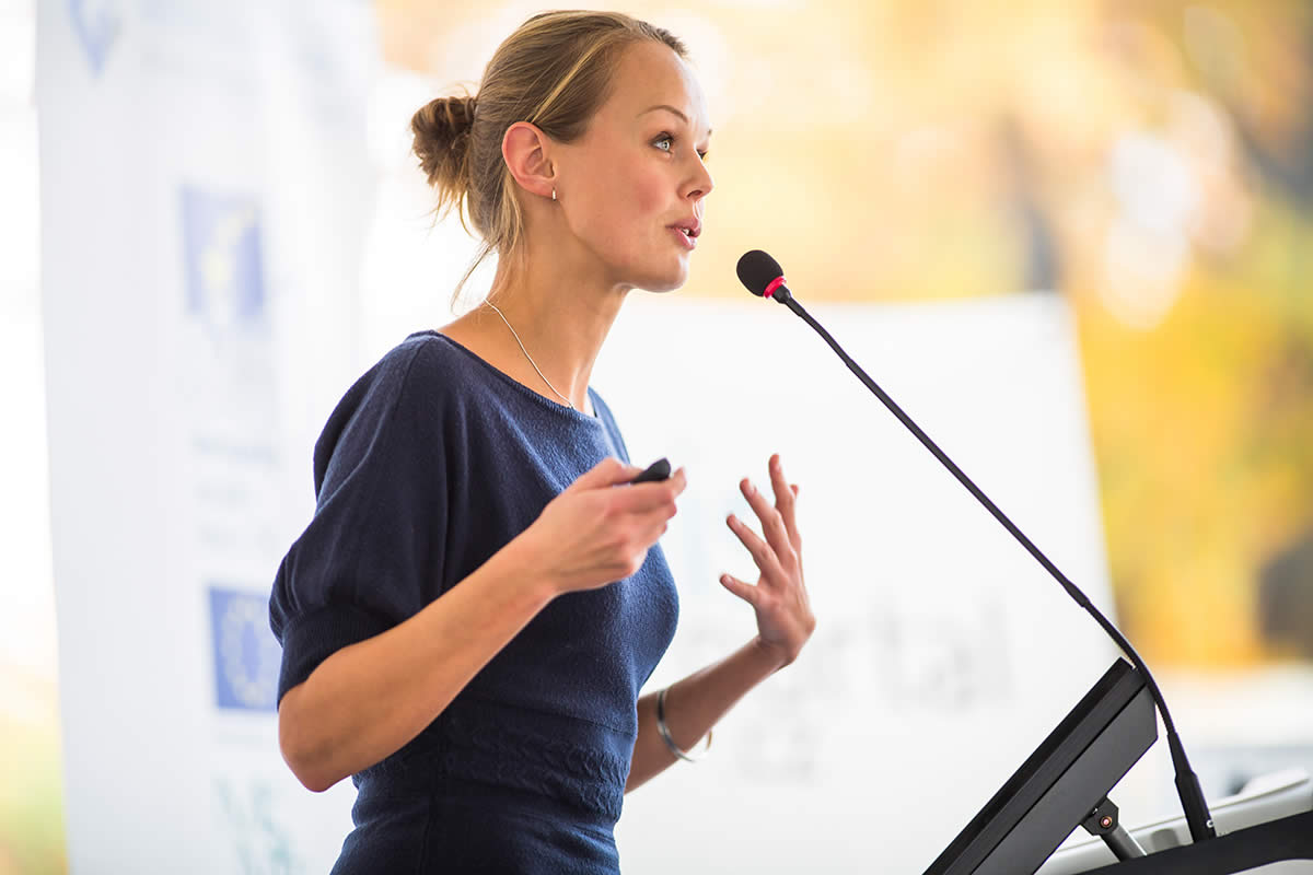 Female inspirational speaker speaking at widow AWM Hope™ Conference.